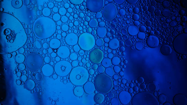 istock Oil drops on a water surface - Water bubbles abstract light illumination 1179311506