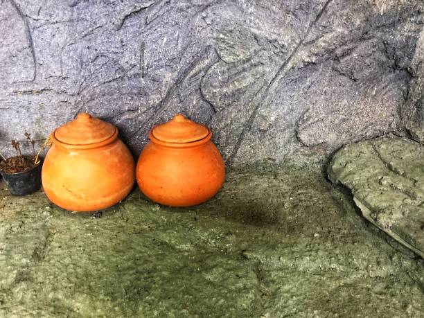 istock Two earthenwares are at the stone wall 1179311570