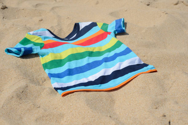 istock Multicolored child t-shirt on the sand 1179312765