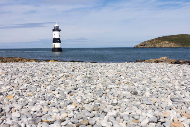istock Penmon lighthouse and shingle beach, Anglesey, Wales 1179317424