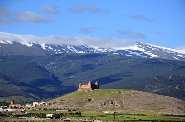 Castle with snow capped mountains of the Sierra Nevada to the rear, La Calahorra, Granada Province, Andalucia, Spain, Europe.