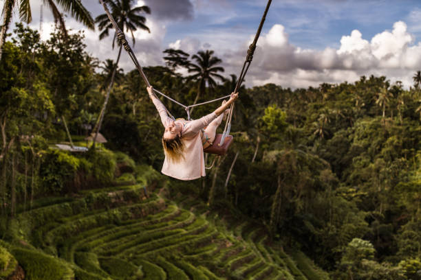 istock Young happy woman enjoying while swinging above the rainforest. 1179320015