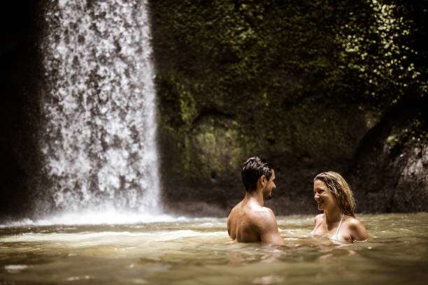 istock Young happy couple talking in water at rainforest. 1179320851