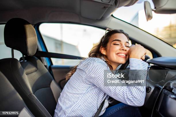 Junge Und Fröhliche Frau Genießt Neues Auto Umarmen Lenkrad Sitzen Im Inneren Stockfoto und mehr Bilder von Auto