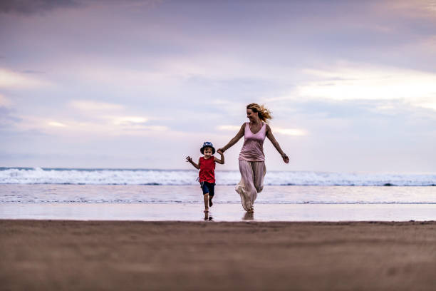 istock Carefree single mother and son having fun while running on the beach. 1179321986
