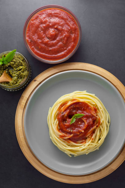 istock Spaghetti pasta with tomatoes sauce and basil in plate on dark background. Pasta plate isolated. Top view with copy space. 1179323385