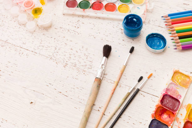 istock Top view on the creative space with whales and paints. Creative ideas, creativity and early learning. Education concept. Watercolors, paint brush and some art stuff on wooden table 1179324693