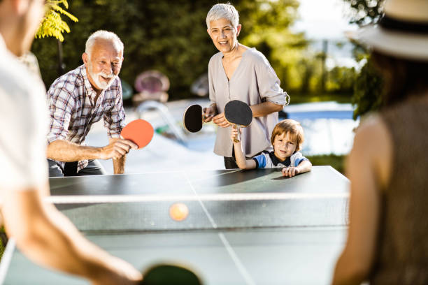 istock Happy extended family having fun while playing table tennis in the backyard. 1179327375