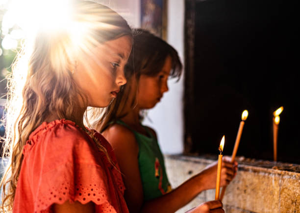 istock Girls holding a candles in chapel 1179328763