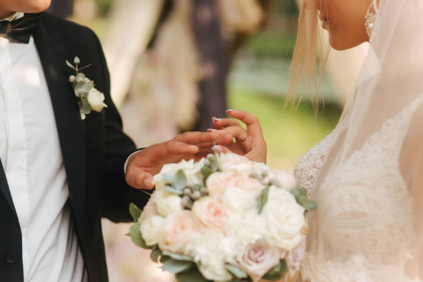 istock Close up of hands groom and bride wearing a ring 1179330285