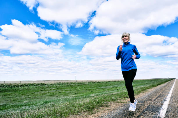 donna anziana che fa jogging, montana, usa - corsa di superstrada foto e immagini stock