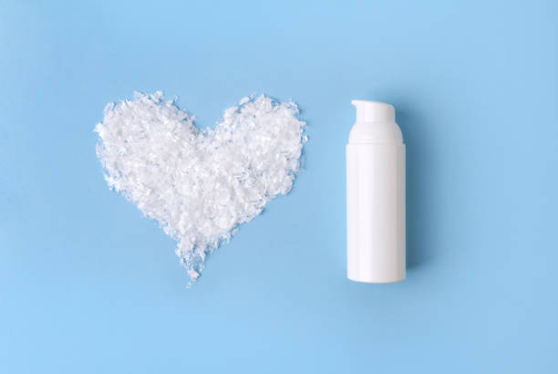 istock Cosmetic cream in a bottle with snow heart on blue background 1179334768