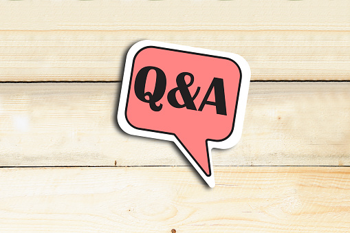 Question And Answer Speech Bubble Isolated On wooden table