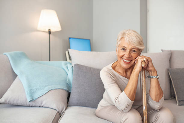 istock Elderly woman with walking stick at home 1179336922