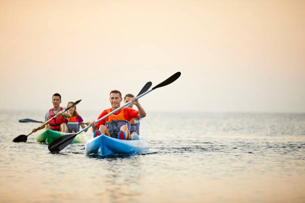 couples kayaking on river during summer sunset - tourists couple barcelona imagens e fotografias de stock