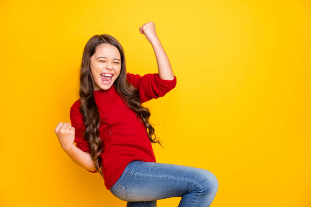 Portrait of delighted positive lucky cheerful kid feel crazy funky rejoice raise fists scream yeah celebrate achievements aims wear style sweater denim jeans isolated over yellow color background Portrait of delighted positive lucky cheerful kid feel crazy funky rejoice raise, fists scream yeah celebrate achievements aims wear style sweater denim jeans isolated over yellow color background ecstatic stock pictures, royalty-free photos & images