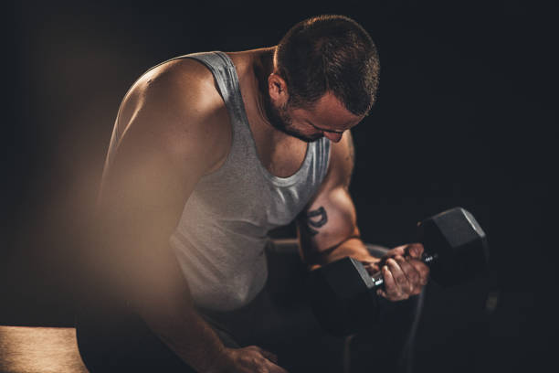istock Muscular man doing exercises with dumbbells 1179338925