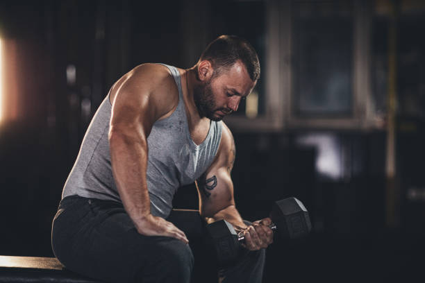 istock Muscular man doing exercises with dumbbells 1179338966