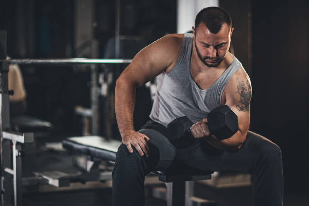 istock Muscular man doing exercises with dumbbells 1179339000