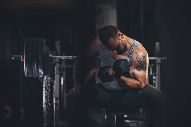 istock Muscular man doing exercises with dumbbells 1179339035