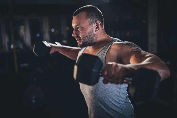 istock Muscular man doing exercises with dumbbells 1179339138