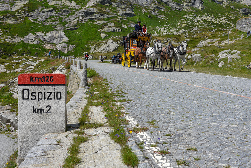 Mount Gotthard, Switzerland - 3 August 2019: horse drawn carriage along the old road of Mount Gotthard on the Swiss alps