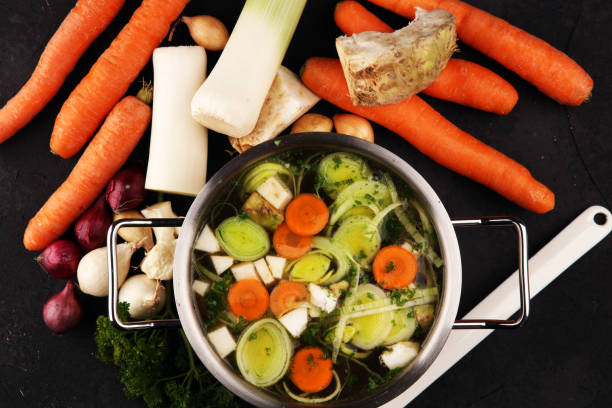 istock Broth with carrots, onions various fresh vegetables in a pot - colorful fresh clear spring soup. Rural kitchen scenery vegetarian broth 1179345002