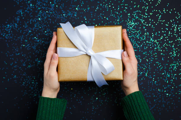 istock gift on the hands, flat lay on a starry background 1179346137