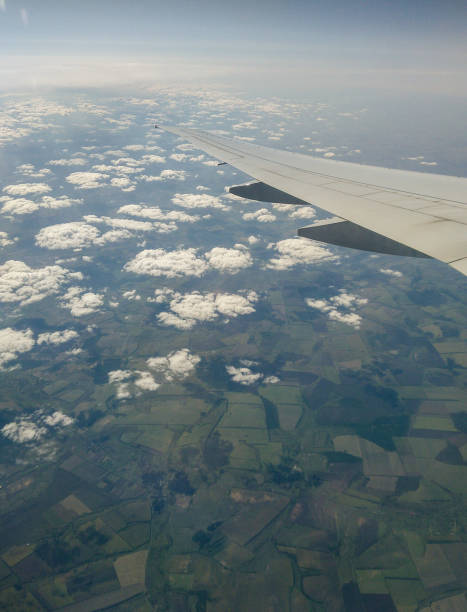 Earth under the wing. The view from the window of the plane to the ground and clouds. earth's atmosphere stock pictures, royalty-free photos & images