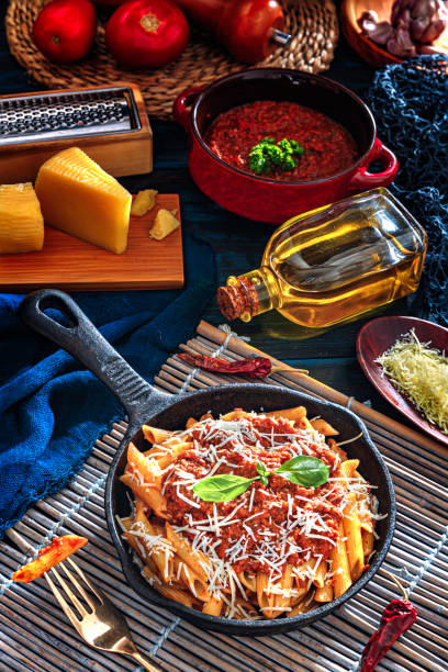 istock Penne with Bolognese sauce in serving size casserole with ingredients in rustic pots 1179347758