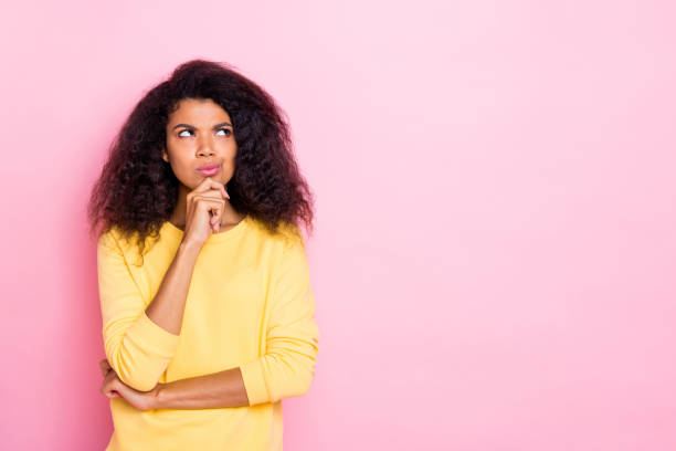 istock Portrait of focused afro girl think solve her future problems about her weekends try find choice decision solution wear yellow pullover isolated over pastel color background 1179349751