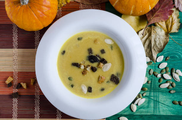 istock pumpkin soup in white plate wooden background 1179351018