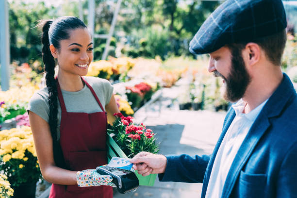 customer at the flower market paying contactless with credit card - florist flower market flower store imagens e fotografias de stock