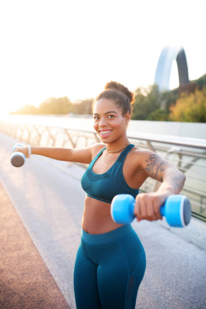 istock Plump woman holding barbells while doing exercise 1179352562
