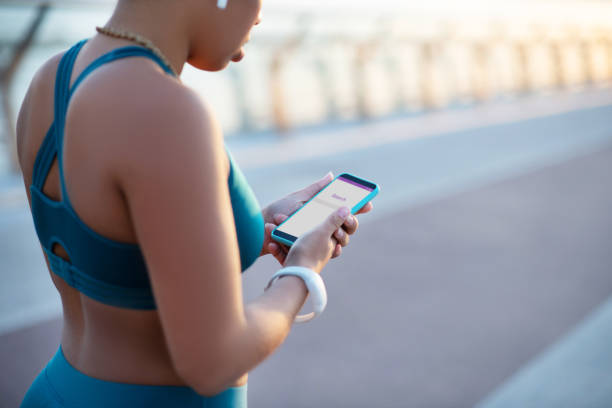 istock Woman holding smartphone while searching music for workout 1179352844