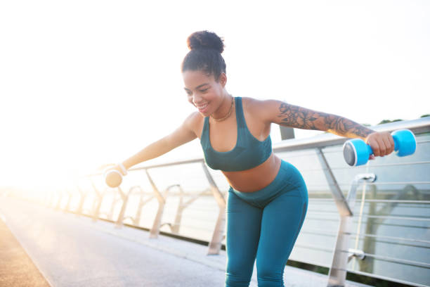 istock Plump tattooed woman feeling satisfied while doing exercises 1179352891