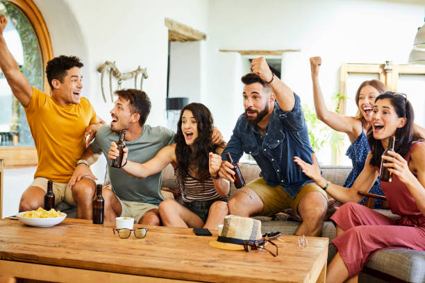 Excited young fans celebrating while watching TV