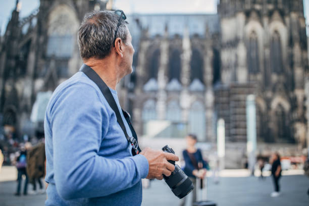 istock Mature man with digital camera on the street 1179354020