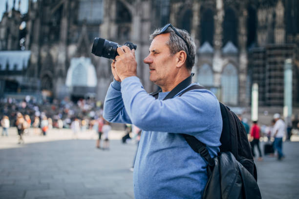 istock Mature man with digital camera on the street 1179354098