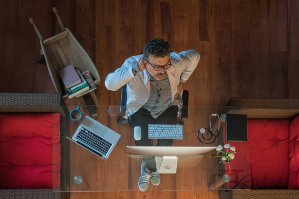 istock Mature doctor sitting in office has a backache 1179354146