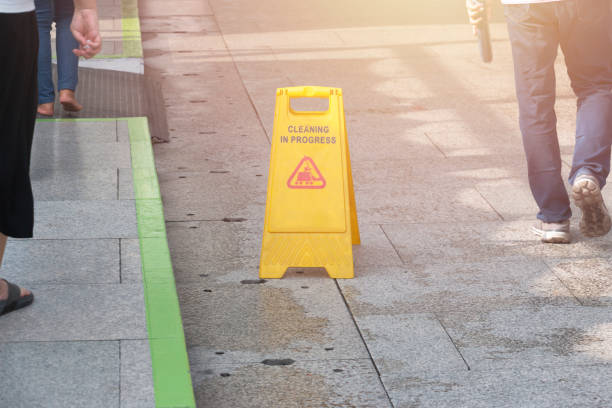 istock Cleaning in progress sign on yellow plastic board on floor with some people walking,Cleaning service in public area. 1179357667