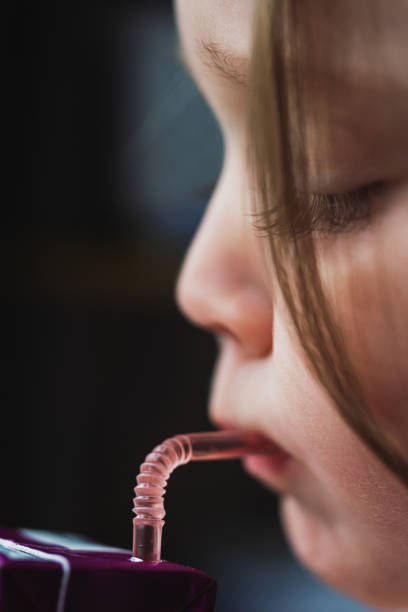 Close-up portrait of a beautiful girl looking up into the corner. Lots of copyspace and room for text on grey wall