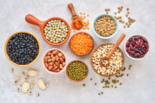 istock Legumes, lentils and beans assortment in different bowls on light stone background . Top view. Healthy vegan protein food. 1179360965