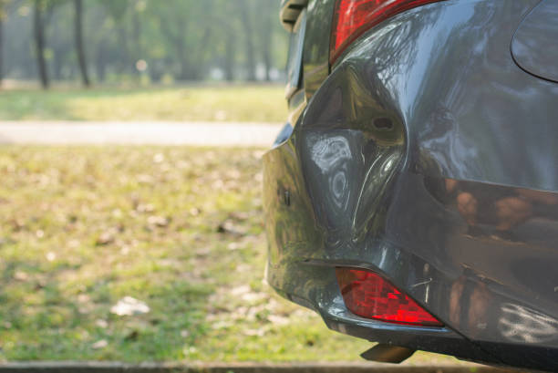 coche un parachoques trasero roto, el coche se detuvo en la carretera que tiene daños o abolladuras en la parte trasera del coche, accidente de coche dañado, espacio de copia. - abollado coche fotografías e imágenes de stock