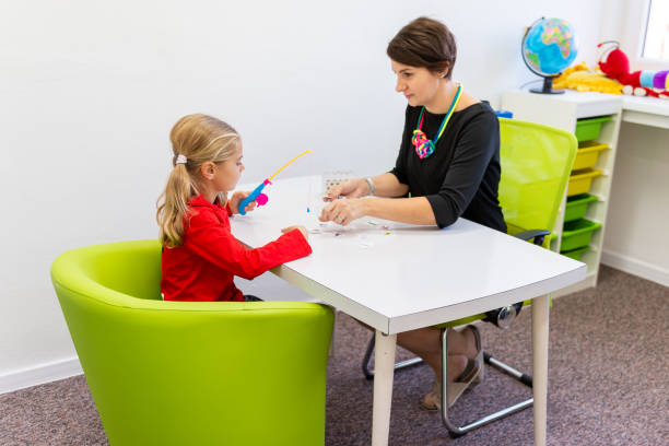 fille d'âge primaire dans la session d'ergothérapie d'enfant faisant des exercices espiègles avec son thérapeute. - occupational therapy photos et images de collection