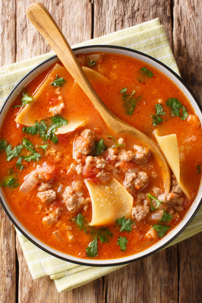 Italian lasagna soup close-up in a plate. Vertical top view from above