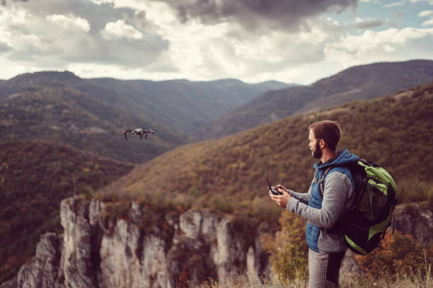 istock Hiker on the mountain top flying a drone 1179370429