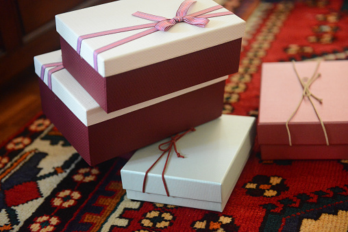 Gift box with gold coloured wrapping paper and a black ribbon and bow