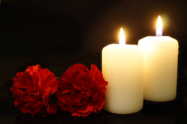istock Two burning candles with flowers 1179371016