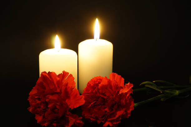 istock Two burning candles with flowers 1179371113